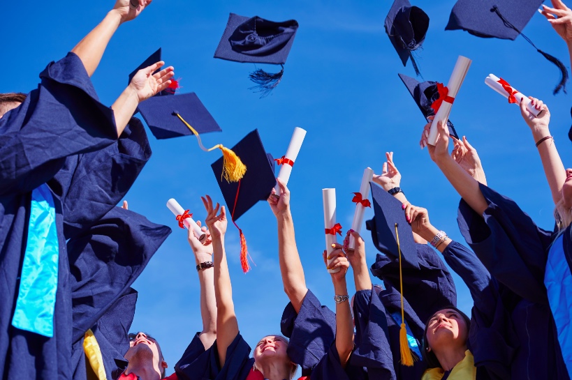 afgestudeerden gooien diploma in de lucht