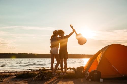 gelukkig jong stel op het strand bij zonsondergang