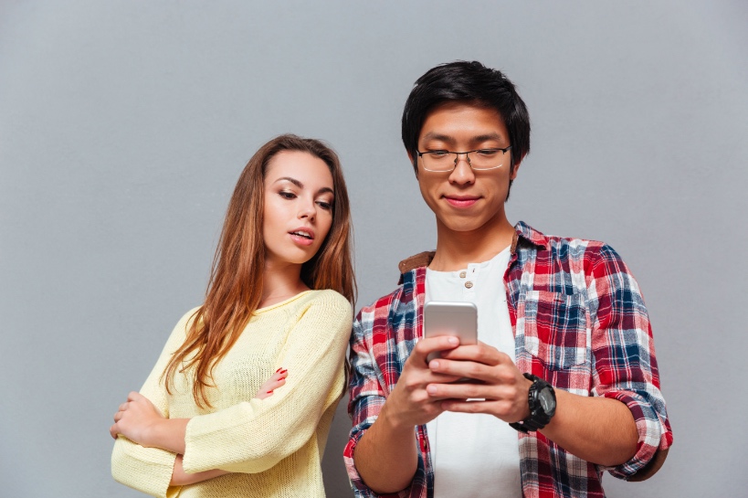 jaloerse vrouw controleert telefoon van haar partner