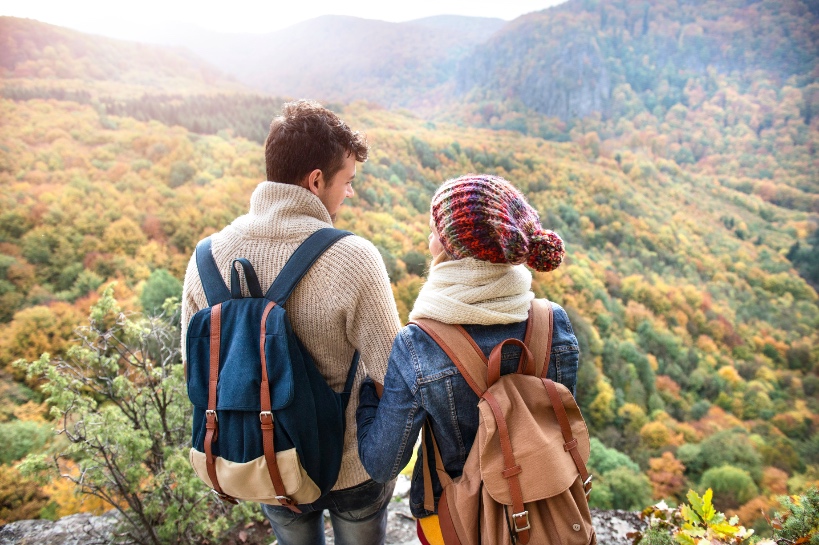 man en vrouw hebben allebei een rugzakje maar helpen elkaar die bagage lichter te maken