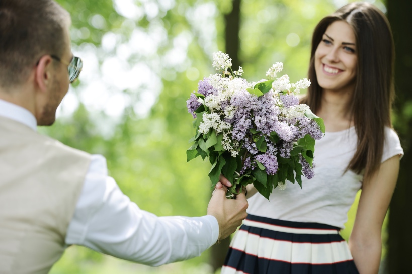 man heeft bosje bloemen meegenomen voor zijn date