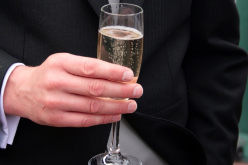 man met glas champagne in zijn hand