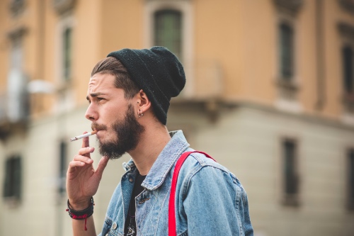man rookt een sigaret op straat