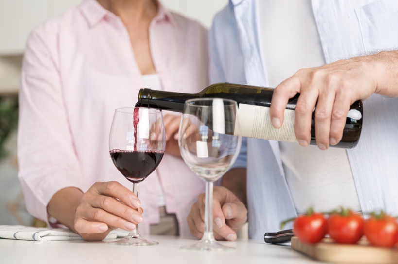 man schenkt wijn in wijnglas vrouw