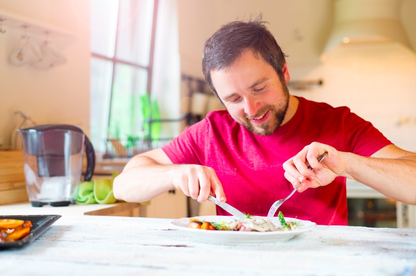 man zit achter bord met eten en plaatst daar een foto van op datingprofiel