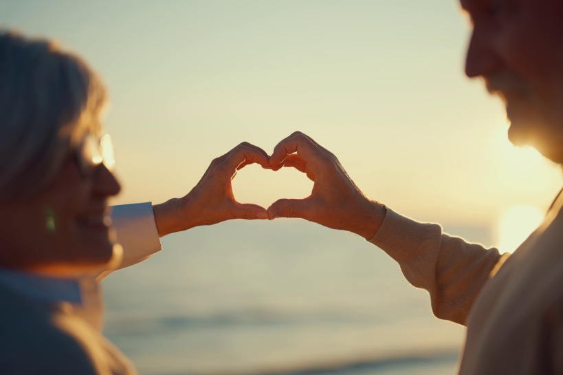 ouder stel maakt hartje met hun handen