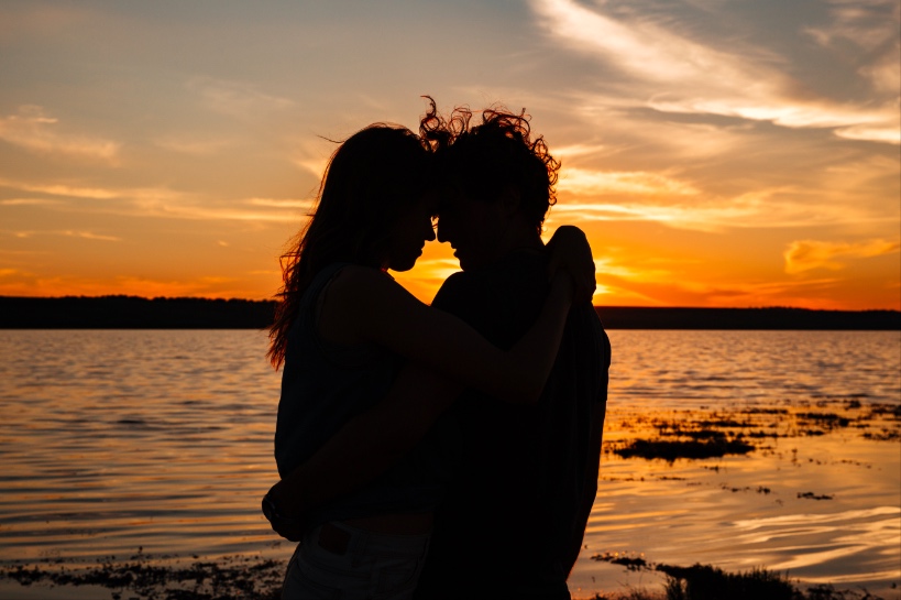 stel knuffelt verliefd voor zonsondergang