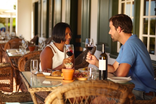 stelletje drinkt gezellig een wijntje op een terras tijdens hun eerste date