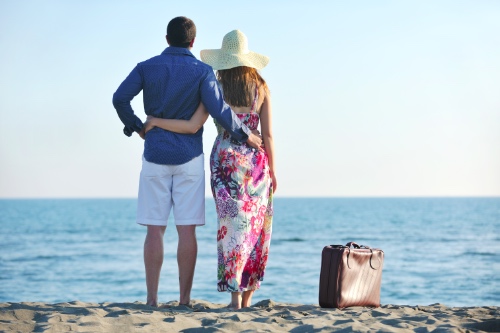 stelletje op strand in land waar de man woonde en waar zij naartoe is verhuisd voor hem