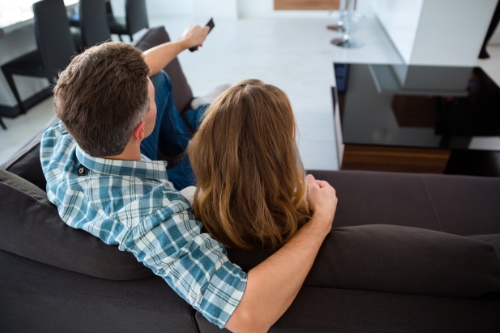 stelletje zit samen op de bank tv te kijken om de dagelijkse sleur te laten zien