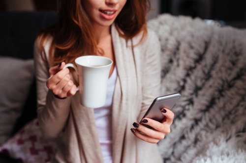 vrouw checkt haar telefoon om te kijken of haar potentiele match nog heeft geappt